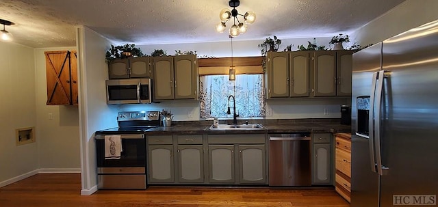 kitchen featuring sink, dark hardwood / wood-style floors, appliances with stainless steel finishes, and a textured ceiling