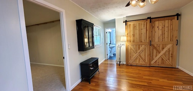 interior space featuring hardwood / wood-style flooring, a barn door, and a textured ceiling