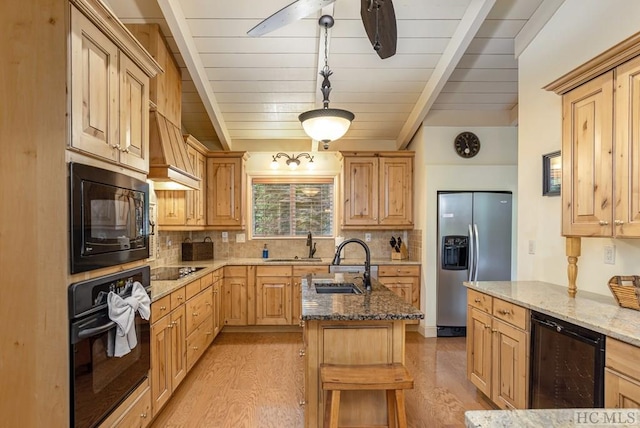 kitchen with sink, beverage cooler, hanging light fixtures, black appliances, and light hardwood / wood-style flooring