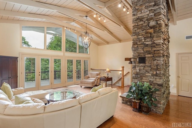 living room featuring hardwood / wood-style flooring, a chandelier, high vaulted ceiling, and beamed ceiling