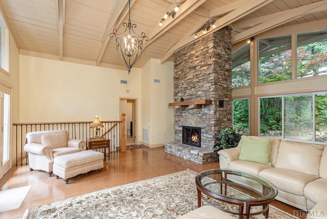 living room with beamed ceiling, a notable chandelier, a fireplace, and high vaulted ceiling