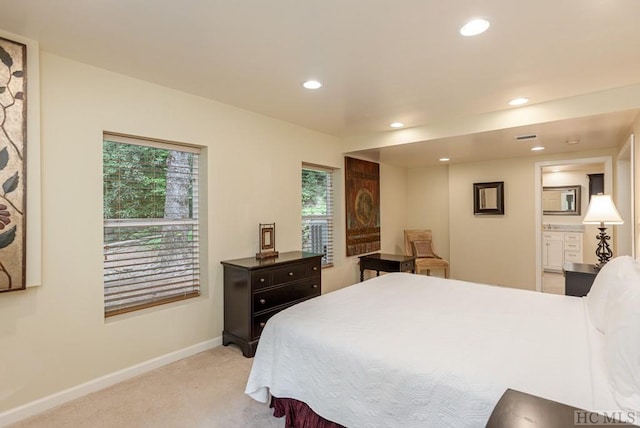 bedroom featuring connected bathroom and light carpet