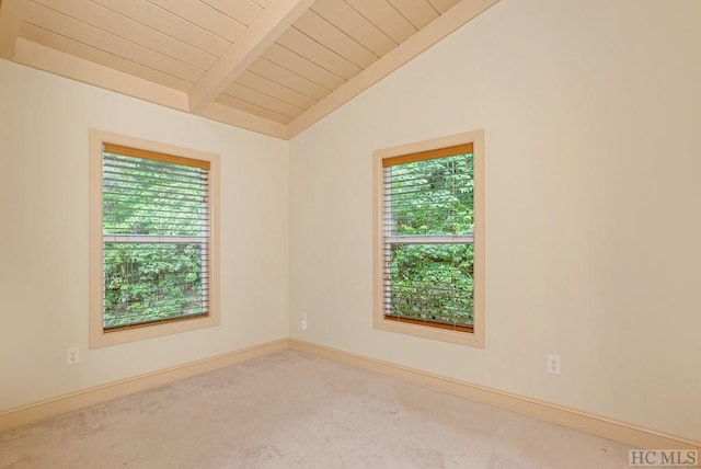 empty room with wooden ceiling, lofted ceiling with beams, carpet flooring, and a healthy amount of sunlight