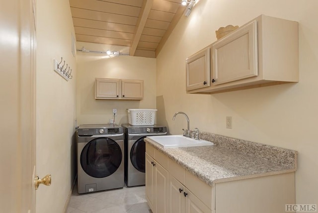 clothes washing area featuring light tile patterned flooring, sink, cabinets, washer and dryer, and wooden ceiling