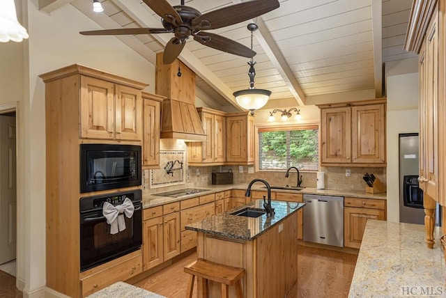 kitchen featuring sink, backsplash, black appliances, and a center island with sink