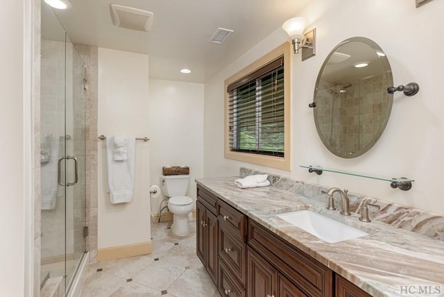 bathroom featuring a shower with door, vanity, and toilet