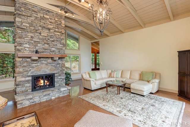 living room with beamed ceiling, wood ceiling, a stone fireplace, and high vaulted ceiling