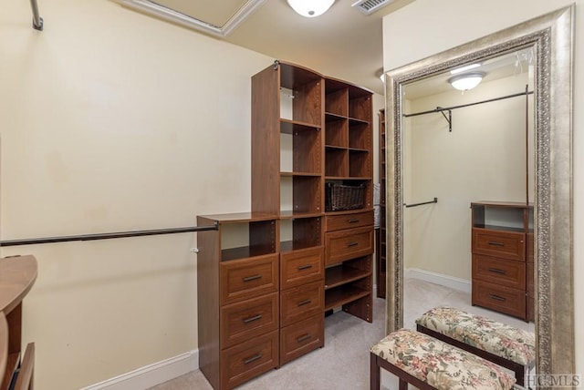 walk in closet featuring light carpet