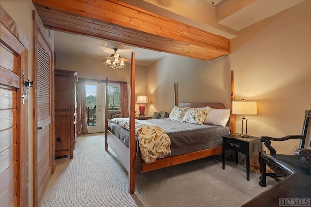 carpeted bedroom with beamed ceiling and access to exterior