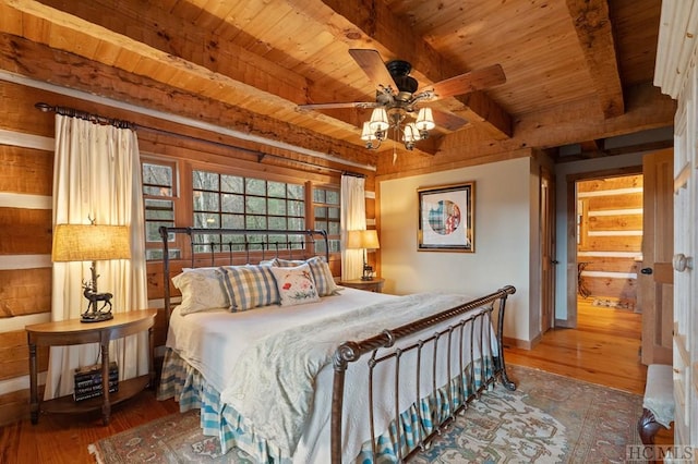 bedroom featuring beam ceiling, hardwood / wood-style flooring, wooden ceiling, and ceiling fan