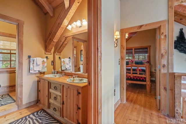 bathroom featuring lofted ceiling with beams, vanity, and hardwood / wood-style floors