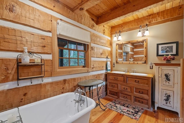 bathroom featuring wooden ceiling, vanity, beamed ceiling, hardwood / wood-style floors, and a washtub