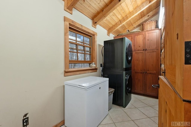 washroom featuring cabinets, stacked washing maching and dryer, light tile patterned floors, and wooden ceiling