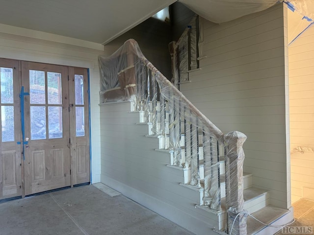 entryway with wood walls