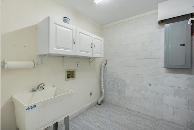 laundry area featuring sink, crown molding, hookup for a washing machine, electric panel, and cabinets