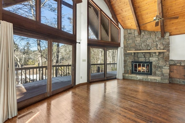 unfurnished living room with wood ceiling, hardwood / wood-style floors, high vaulted ceiling, a fireplace, and beamed ceiling