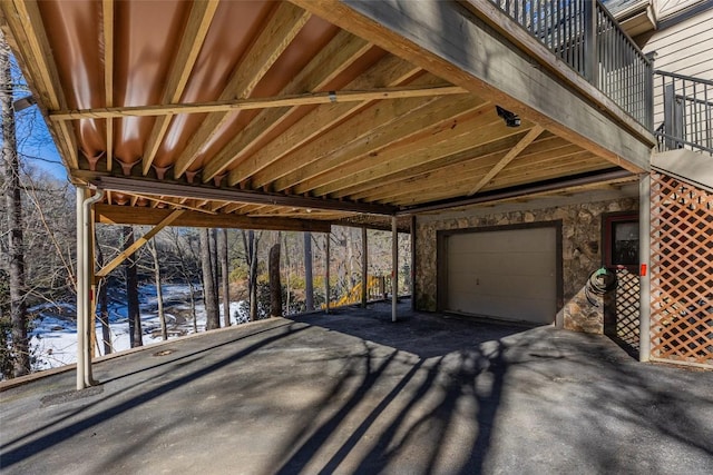 snow covered patio featuring a balcony and a garage