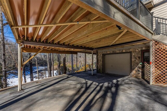 snow covered patio featuring a garage and a balcony