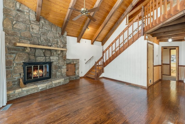 unfurnished living room with wood ceiling, ceiling fan, a fireplace, dark hardwood / wood-style flooring, and beamed ceiling