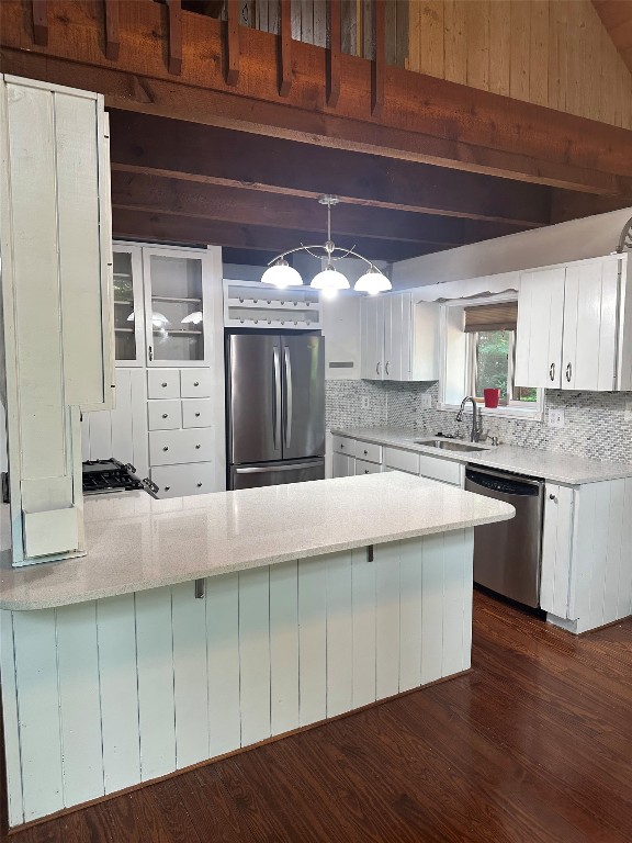 181 Hiwassee Rd, Lake Toxaway, NC 28747 - kitchen featuring stainless steel appliances, a peninsula, white cabinetry, tasteful backsplash, and dark wood-style floors