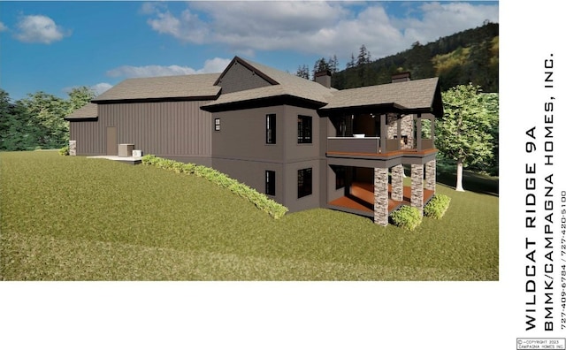 back of house with a balcony, a yard, and a chimney