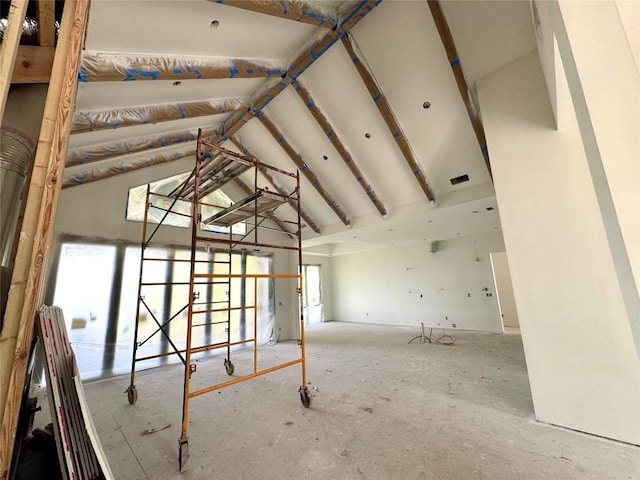 empty room featuring plenty of natural light and high vaulted ceiling
