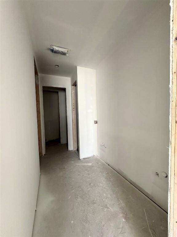 corridor featuring unfinished concrete flooring