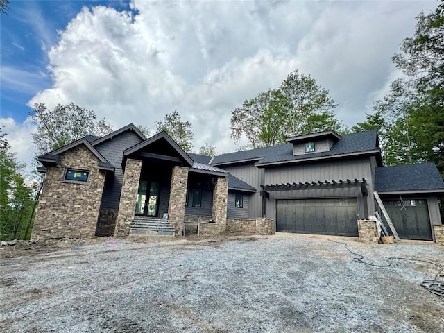 2385 Magnolia Dr, Highlands, NC 28741 - view of front of house featuring stone siding, driveway, board and batten siding, and an attached garage