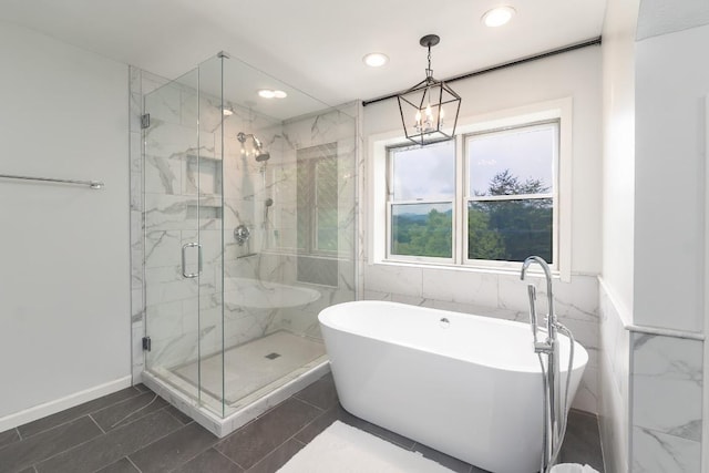 bathroom featuring a soaking tub, a marble finish shower, recessed lighting, baseboards, and a chandelier