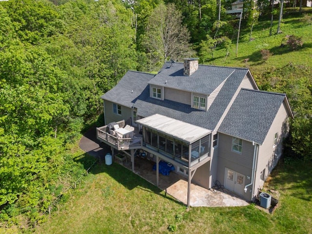 aerial view of property and surrounding area with a heavily wooded area