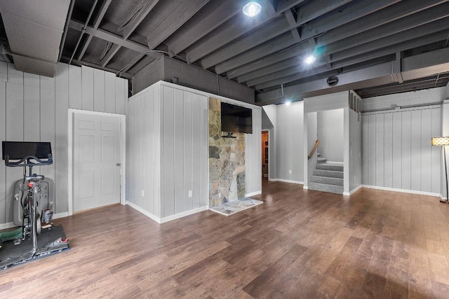 finished below grade area with wood finished floors, stairs, baseboards, and wood walls