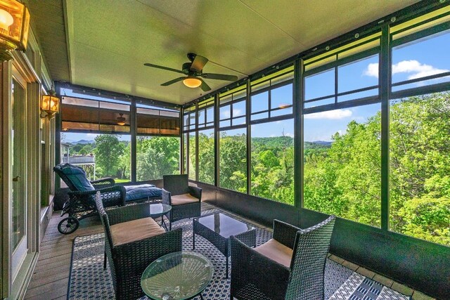 sunroom / solarium featuring a ceiling fan, healthy amount of natural light, and outdoor lounge area