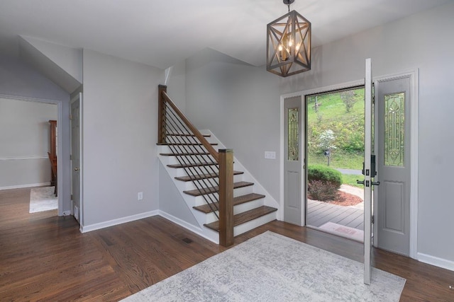 foyer featuring stairs, wood finished floors, baseboards, and a chandelier