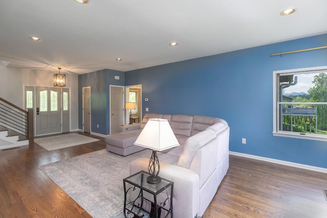 living area featuring stairway, plenty of natural light, baseboards, wood finished floors, and recessed lighting