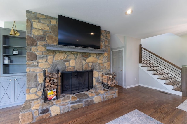 detailed view of wood finished floors, baseboards, and a fireplace