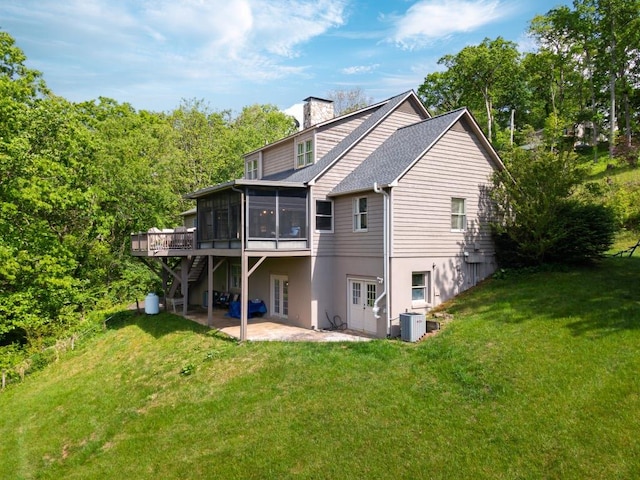 back of house with a sunroom, french doors, a patio, cooling unit, and a yard
