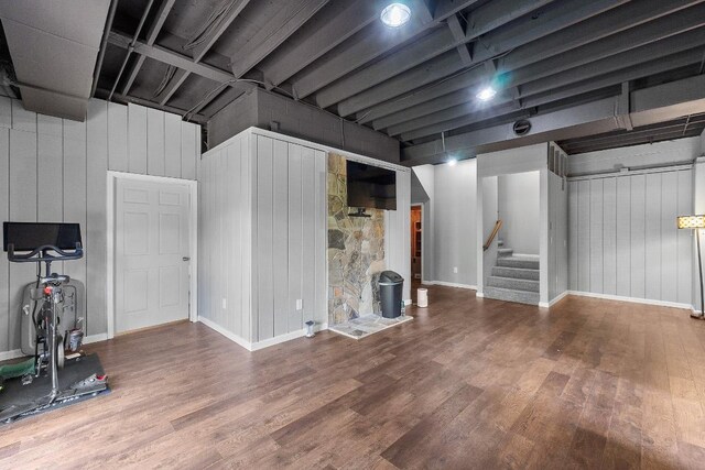 below grade area featuring wood finished floors, stairway, baseboards, and wooden walls
