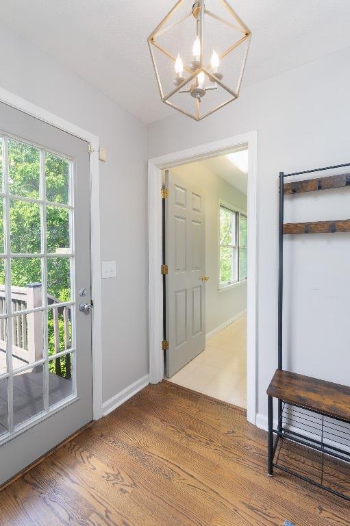 foyer entrance featuring a chandelier, light wood-style floors, and baseboards