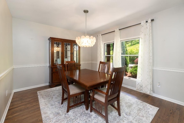 dining room featuring a chandelier, wood finished floors, and baseboards