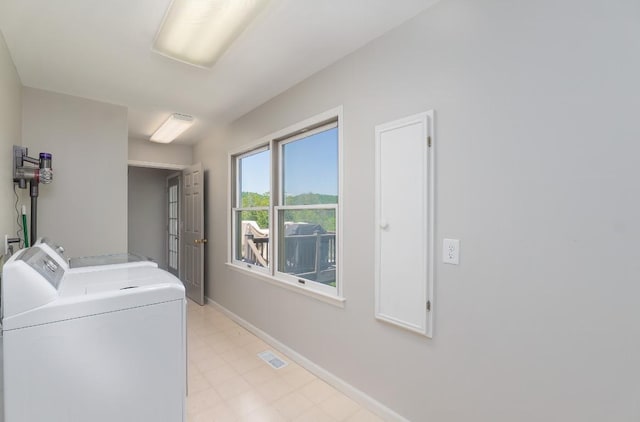 laundry room featuring washing machine and dryer, baseboards, and light floors