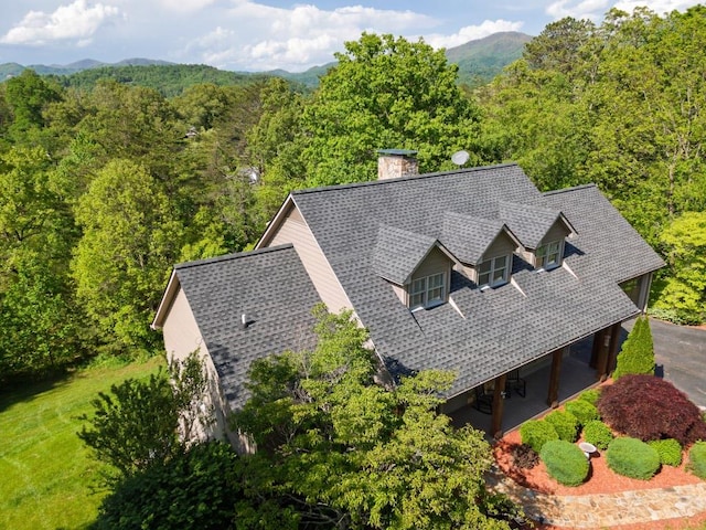 aerial view of property and surrounding area featuring a heavily wooded area