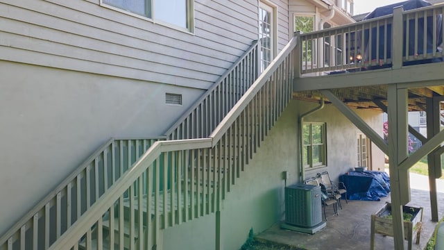 view of property exterior with stairway, cooling unit, a deck, and a patio