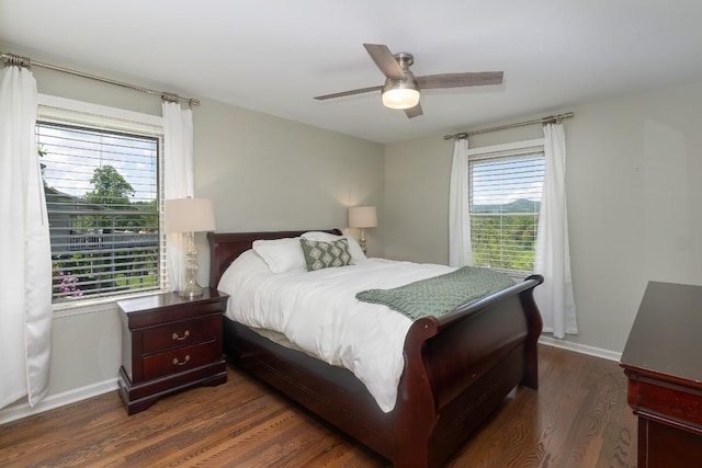 bedroom featuring dark wood-style floors, a ceiling fan, and baseboards