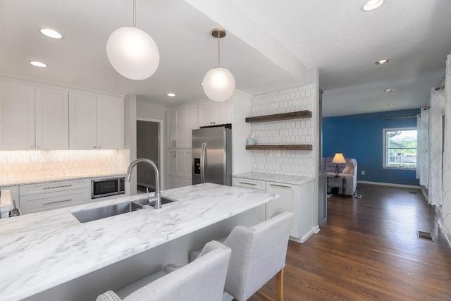 kitchen with appliances with stainless steel finishes, a sink, white cabinetry, backsplash, and open shelves