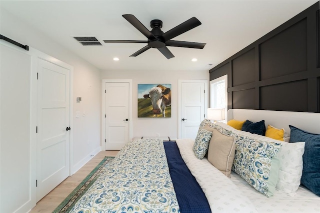 1018N Norton Rd, Cashiers, NC 28717 - bedroom featuring light wood-style floors, recessed lighting, a ceiling fan, and a barn door