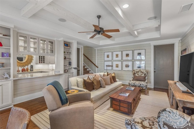 living room with light hardwood / wood-style flooring, ceiling fan, beam ceiling, wooden walls, and coffered ceiling