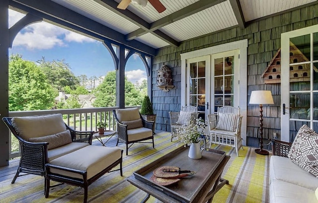 sunroom / solarium with ceiling fan and beam ceiling