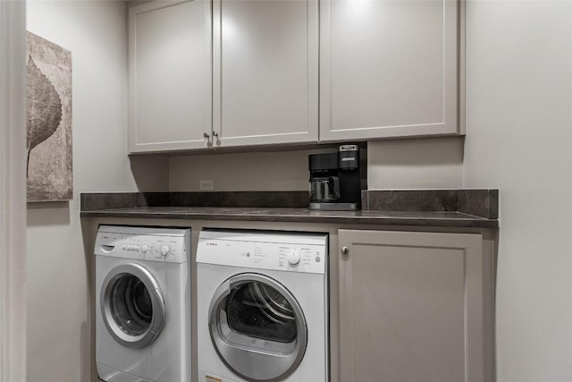 clothes washing area with washer and clothes dryer and cabinets