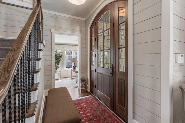 entryway with hardwood / wood-style flooring and wood walls