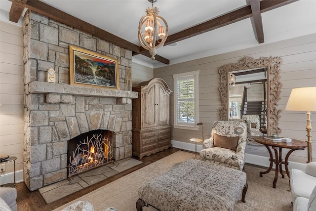 living area featuring a stone fireplace, dark hardwood / wood-style flooring, beam ceiling, and wood walls